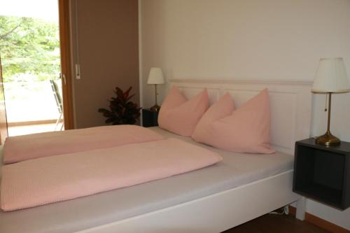 een slaapkamer met een bed met roze kussens en een televisie bij Appartment Larcher - Meinhard in Merano