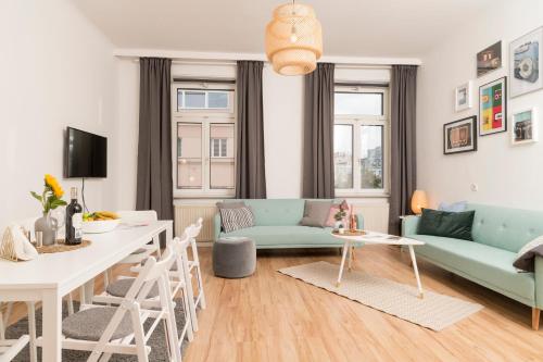 ein Wohnzimmer mit einem Sofa und einem Tisch in der Unterkunft Spittelau Chillout Lounge upto7P spacious bright contactless24h in Wien
