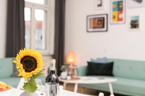 eine Flasche Wein und eine Sonnenblume auf dem Tisch in der Unterkunft Spittelau Chillout Lounge upto7P spacious bright contactless24h in Wien