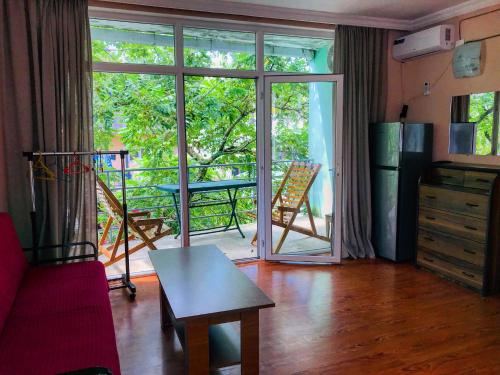uma sala de estar com uma porta que abre para uma varanda em Green Hotel Ureki em Ureki