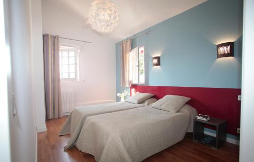 - une chambre avec 2 lits et un mur rouge et bleu dans l'établissement Résidence Prestige Odalys Le Domaine de Lana, à Urrugne
