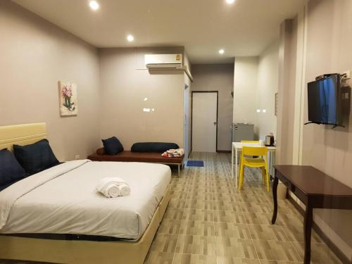 a bedroom with a bed and a desk and a television at The Cube Resort in Chanthaburi