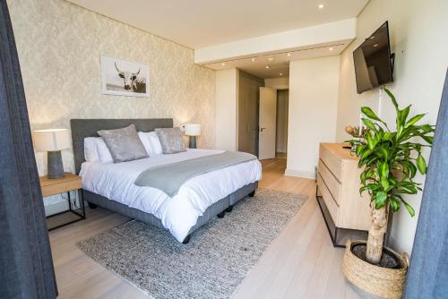 a bedroom with a bed and a television in it at Elegant Waterfront Apartment with No Loadshedding in Cape Town