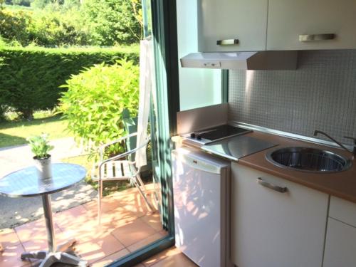 a kitchen with a view of a patio with a table at Apartamentos del Norte in Andrín