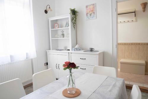 a dining room with a vase of flowers on a table at Katus Apartman in Eger