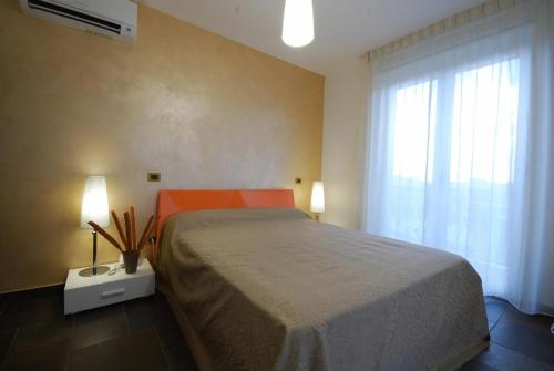 ein Schlafzimmer mit großem Bett und Fenster in der Unterkunft Olympus Resort in Alba Adriatica