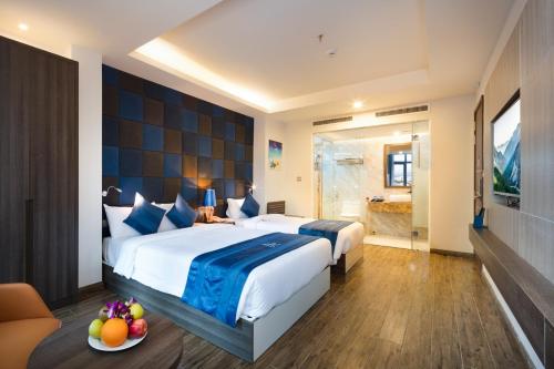a hotel room with two beds and a bathroom at Aaron Hotel in Nha Trang