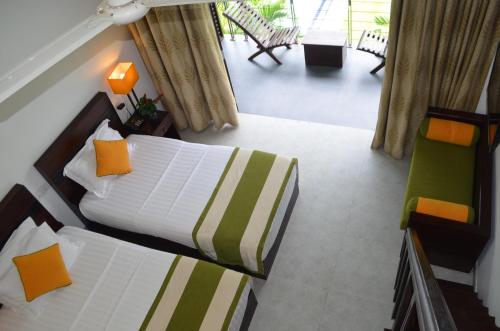 a hotel room with two beds and a balcony at Nature Trails Boutique Hotel in Unawatuna