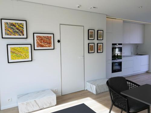 a white living room with a table and a kitchen at akemi b&b in Zemst