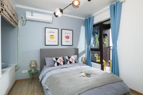 ein Schlafzimmer mit einem Bett mit blauen Wänden in der Unterkunft lu ke boutique apartment 00123370, qixiashan nanjing station, nanjing city, jiangsu province in Nanjing