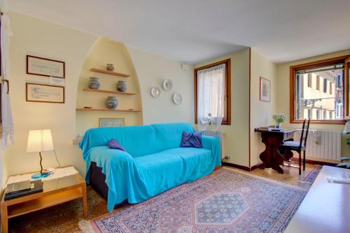 a living room with a blue couch and a table at CANDIANO Cruise-Port in Venice