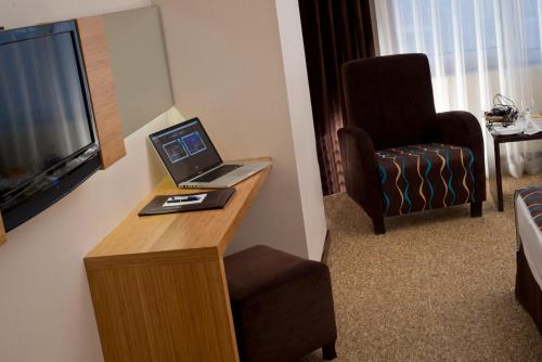 a hotel room with a desk with a laptop and a chair at North Point Hotel in Denizli