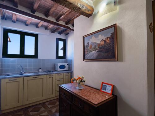 a kitchen with a sink and a painting on the wall at B&B Siena In Centro - Diffuso in Siena