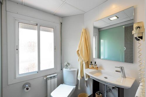 a bathroom with a toilet and a sink and a window at Bonanova Park in Barcelona