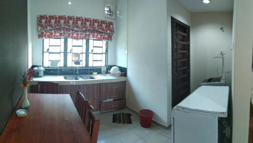 una cucina con tavolo, lavandino e finestra di HMA Guesthouse a Sepang