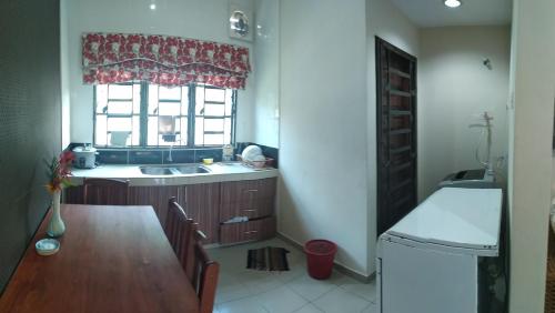 cocina con mesa, fregadero y ventana en HMA Guesthouse en Sepang