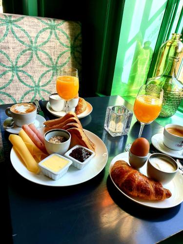a table with plates of breakfast foods and glasses of orange juice at De Buren in Vleuten