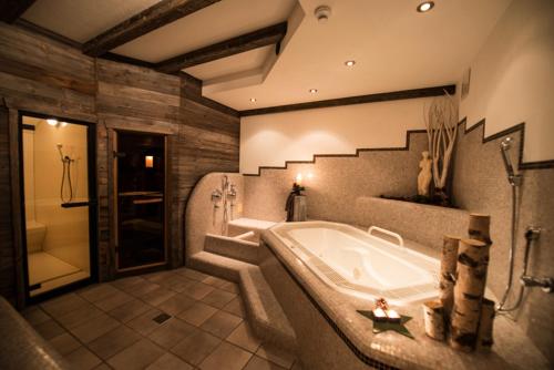 a large bathroom with a tub and a shower at Apparthotel Central in Campo Tures