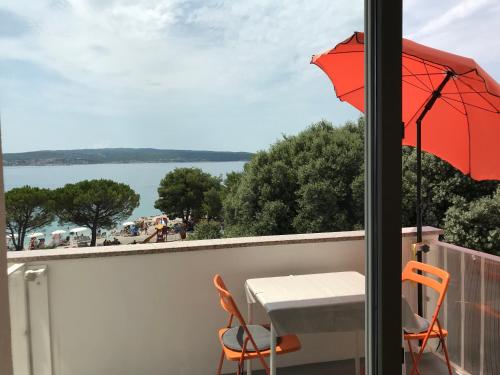 a balcony with a table and a red umbrella at Apartment Romeo in Crikvenica