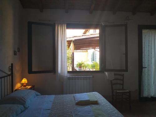 1 dormitorio con 2 camas y ventana en B&B Is Camminantis, en Nurallào