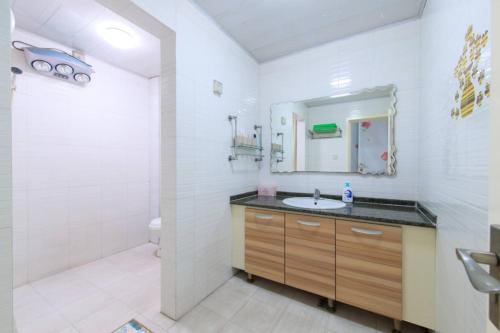 a bathroom with a sink and a shower and a mirror at Baoding Jingxiu·Beiguo Shopping Mall· in Baoding