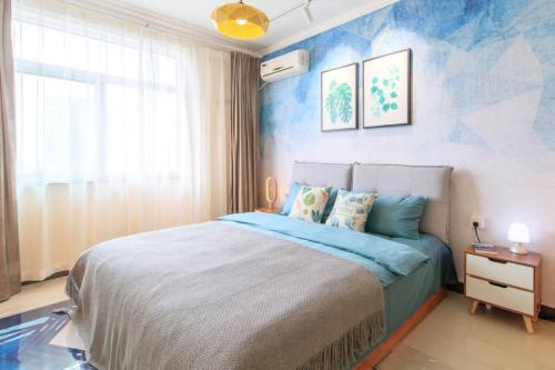 a bedroom with a large bed with blue walls at Baoding Jingxiu·Beiguo Shopping Mall· in Baoding