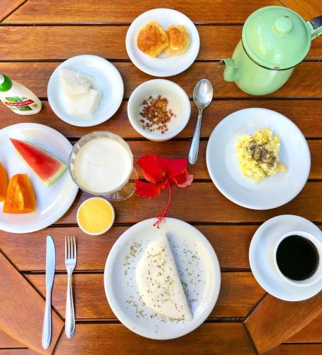 un tavolo sormontato da piatti di cibo e bevande di Pousada Abaré a Itacaré