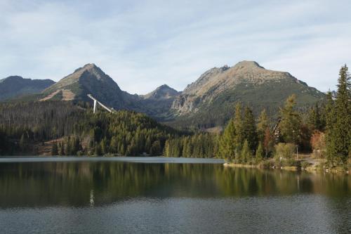 
a lake with mountains and a mountain range at Hotel Solisko in Štrbské Pleso
