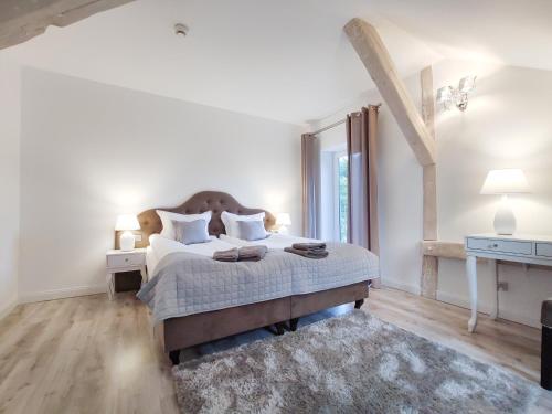 a white bedroom with a bed and a large window at Mazurski Diament koło Mrągowa in Sorkwity