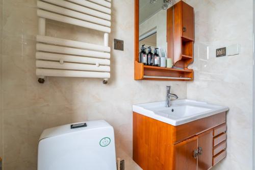 La salle de bains est pourvue d'un lavabo, de toilettes et d'un miroir. dans l'établissement Zhengzhou Jinshui·Phoenix Tea City·, à Zhengzhou