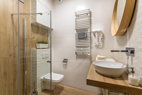 uma casa de banho com um lavatório, um WC e um chuveiro em Apartament Jagiełły (wroc4night) em Breslávia