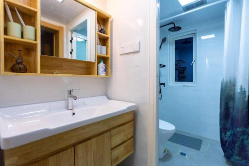 La salle de bains est pourvue d'un lavabo et d'une douche. dans l'établissement Wuhan Jiangan·Central hospital·, à Jiang'an
