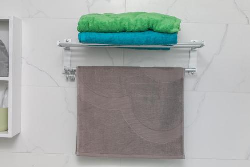 einen Handtuchhalter mit zwei Handtüchern und einem grünen Handtuch in der Unterkunft Chengdu Dujiangyan·DuJiangYan· in Chengdu