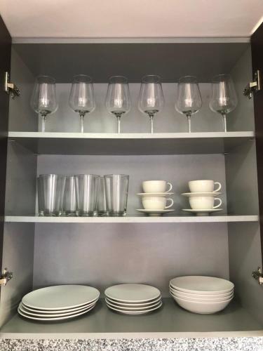 a shelf with plates and wine glasses in a kitchen at Family Home Drago Chill Out in Icod de los Vinos