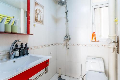 a bathroom with a white sink and a toilet at Zhengzhou Jinshui · North 3rd Ring Huayuan Road·Locals Apartment · 00174560 in Zhengzhou