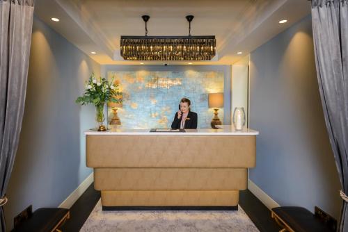 a woman is sitting at a reception desk in a lobby at The Victoria in Killarney