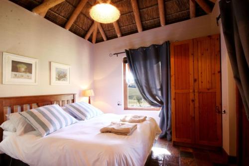 a bedroom with a bed with towels on it at Oudebosch Guest Farm in Riversdale