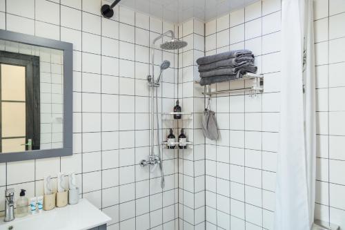 a white tiled bathroom with a shower and a sink at [Roader] Wuhan Jianghan District, Xinhua Road in Wuhan