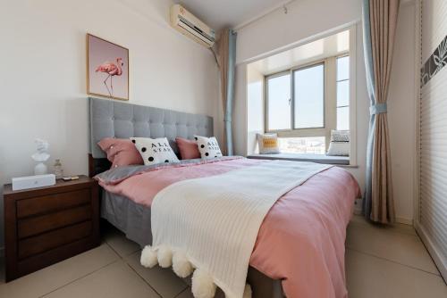 a bedroom with a large bed with pink and white sheets at Xi'an Lianhu.Beidajie International in Xi'an