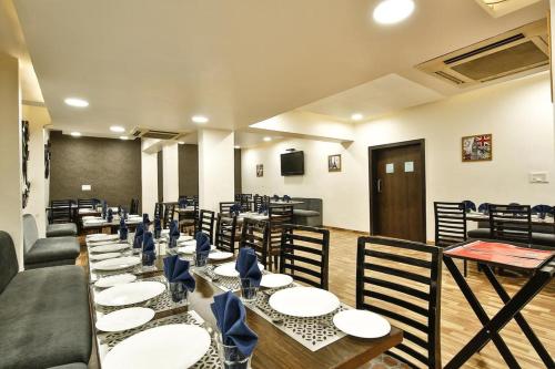 a dining room with tables and chairs and a chalkboard at Epsilon Hotel in Ahmedabad