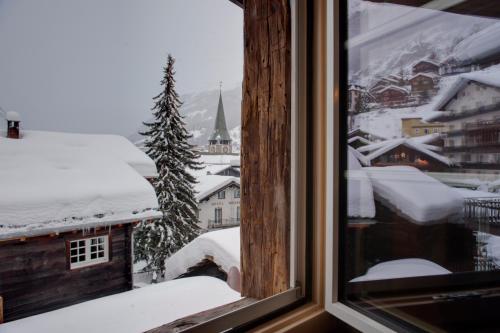 a window with a view of a snow covered city at Chalet Schtuba in Zermatt