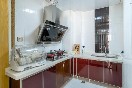 uma cozinha com um lavatório e uma torradeira num balcão em ChangSha Tianxin·Xiang Han imperial house em Changsha