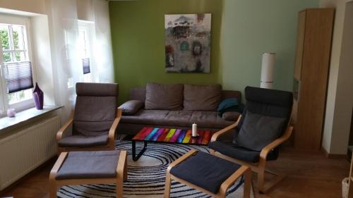 uma sala de estar com um sofá e duas cadeiras em Ferienwohnung Gartenblick em Westerstede