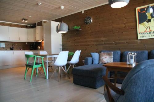 a living room with a blue couch and a table and chairs at Myrkdalen Resort Årmotssteien in Vossestrand