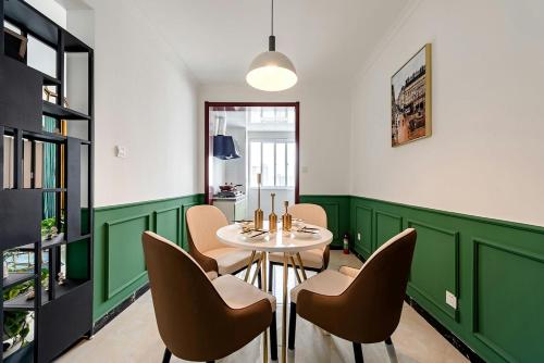 ein Esszimmer mit grünen Wänden und einem Tisch und Stühlen in der Unterkunft Xi 'an lianhu district · kaiyuanmen · Luke boutique apartment ·00184770 in Xi'an