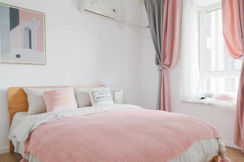 a bedroom with a bed with pink and white sheets at [Passenger] Wuhan，Qiekou District, Liji North Road in Wuhan