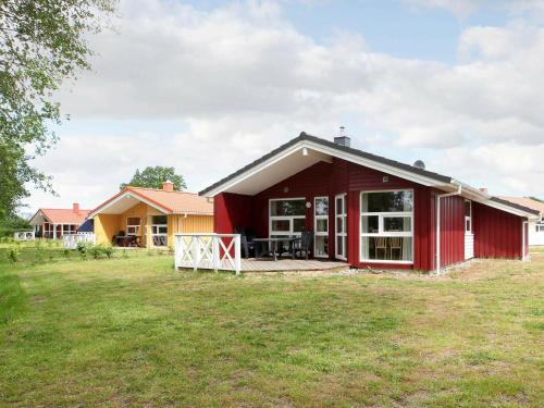 uma casa vermelha com um grande quintal em frente em 6 person holiday home in GROEMITZ em Grömitz