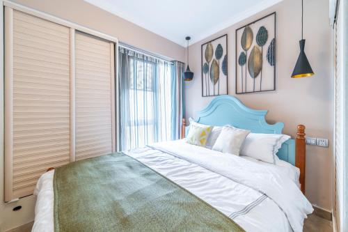 a bedroom with a blue and white bed and a window at Zhengzhou Erqi · Erqi Wanda Complex · in Zhengzhou