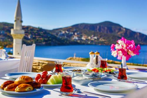 a table with plates of food and a view of the ocean at Zinbad Hotel Kalkan in Kalkan