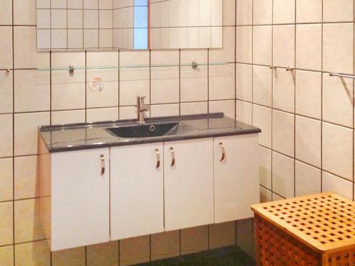 La salle de bains est pourvue d'un lavabo et d'un miroir. dans l'établissement Three-Bedroom Holiday home in Hadsund 28, à Odde